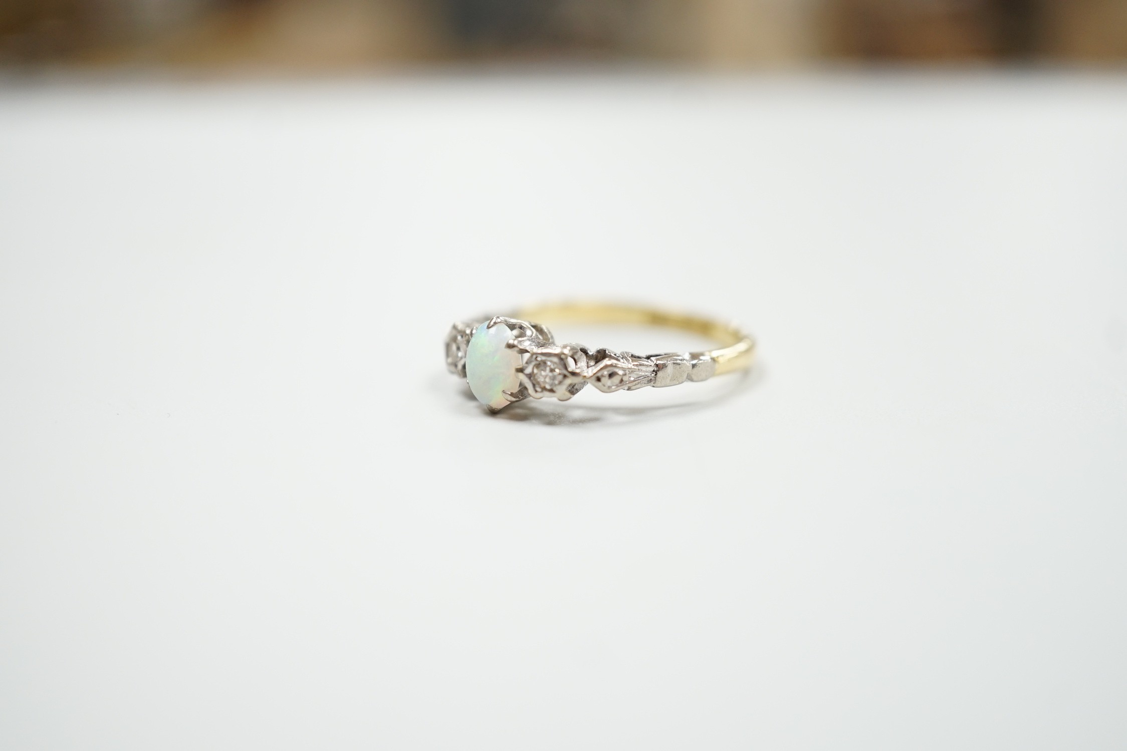 An 18ct and plat, single stone cabochon white opal and two stone diamond set ring, size L/M, gross weight 2.8 grams.